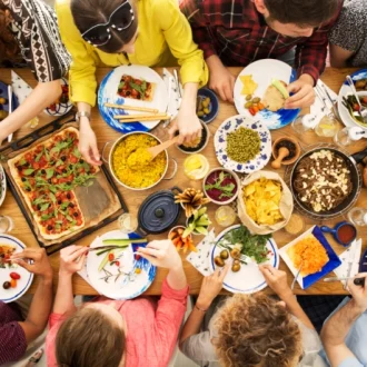 Banquete com pratos veganos e 6 pessoas ao redor